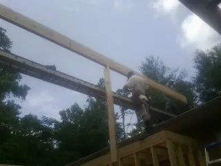Carpenter setting a ridge beam over a new addition frame — Ice Dam Removal by Roofing Brothers in Twinsburg
