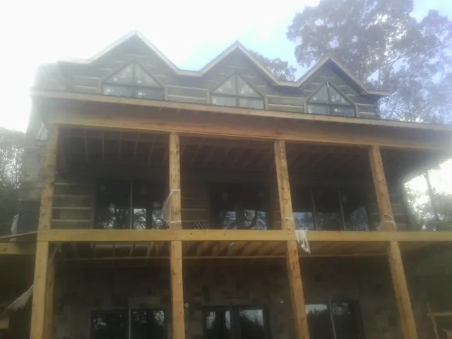 Dormers and porch framing on a large log home under construction — Roof Coating work by our crew in Twinsburg