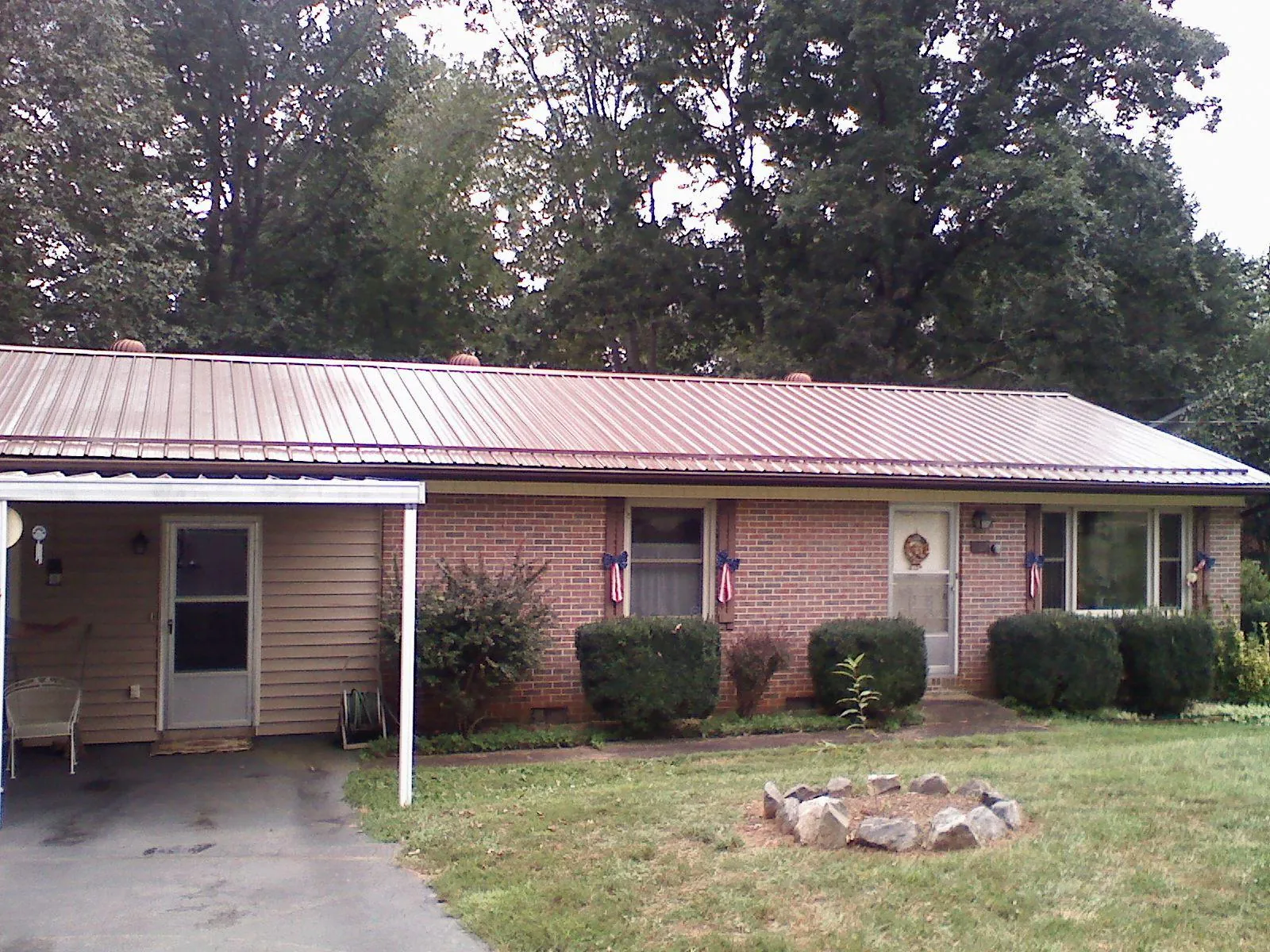 Bronze metal roof and carport on a brick ranch home — Roof Repair work by our crew in Twinsburg