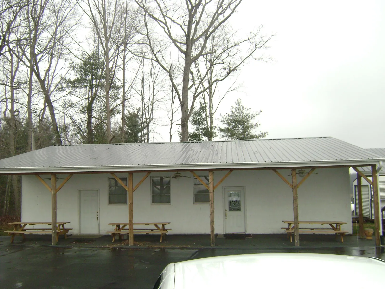 Gray metal roof over a block building with a timber post porch in Twinsburg